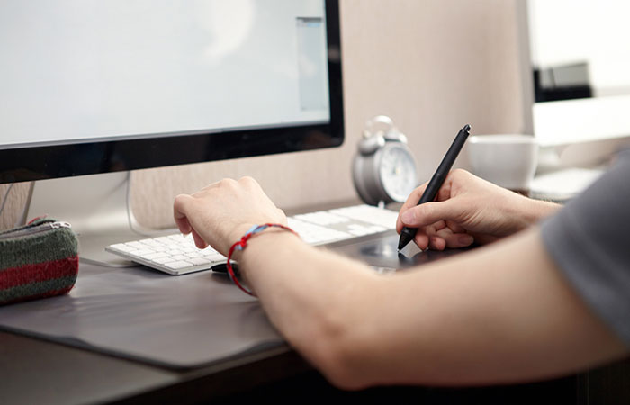 A person using a computer on top of a desk.