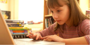 A young girl is using her laptop at home.